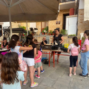 Street food σε υπαίθρια αγορά με πολύχρωμους πάγκους φαγητού, σεφ που ετοιμάζει γρήγορα λιχουδιές και πλήθος κόσμου που απολαμβάνει παραδοσιακές street food γεύσεις